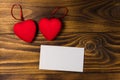 Valentine`s day blank greeting card and two red hearts on wooden background Royalty Free Stock Photo