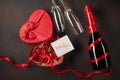 Valentine`s Day with a box of chocolates in the form of a heart with a bottle of champagne with glasses and a note Royalty Free Stock Photo