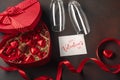 Valentine`s Day with a box of chocolates in the form of a heart with a bottle of champagne with glasses and a note Royalty Free Stock Photo