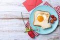 Valentine\'s Day breakfast with egg with tomatoes, heart shaped and toast bread on wooden table