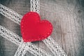 Valentine`s day card. Red felt heart on lace and wooden table background with copy space. Royalty Free Stock Photo