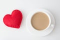 Valentine`s day card. White cup of hot coffee with milk and red felt heart on white. Top view. Royalty Free Stock Photo