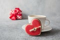 Valentine`s day card. White cup of latte coffee with milk, gift and red heart cookies on grey. Close up Royalty Free Stock Photo