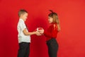 Valentine`s day celebration, happy caucasian kids isolated on red background Royalty Free Stock Photo