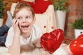 Valentine`s Day children or kids. Cute little boy with a gadget, a mobile phone and a red heart-shaped balloon in his hand, on Royalty Free Stock Photo