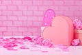 Valentine`s day composition with pink roses, flower petals, heart shaped gift box in front of brick wall Royalty Free Stock Photo