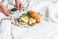 Valentine`s day concept. Breakfast in bed on Valentine`s Day. Sandwiches with croissant, bagel, cream cheese and fried eggs hear