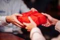 Valentine`s Day concept. Close shot of man`s and woman`s hands presenting gifts to each other at a cafe. A young loving couple Royalty Free Stock Photo