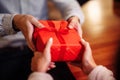 Valentine`s Day concept. Close shot of man`s and woman`s hands presenting gifts to each other at a cafe. A young loving couple Royalty Free Stock Photo