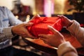 Valentine`s Day concept. Close shot of man`s and woman`s hands presenting gifts to each other at a cafe. A young loving couple Royalty Free Stock Photo