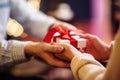 Valentine`s Day concept. Close shot of man`s and woman`s hands presenting gifts to each other at a cafe. A young loving couple Royalty Free Stock Photo