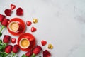 Valentine`s day concept with coffee cups, heart shape chocolate and rose flowers on bright background. Top view. Flat lay