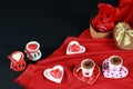 Valentine`s day concept. Coffee in heart shaped cup with candle and teddy bear in gift box on black background. Royalty Free Stock Photo