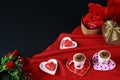 Valentine`s day concept. Coffee in heart shaped cup with candle and teddy bear in gift box with red roses on black background. Royalty Free Stock Photo