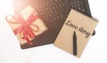 Valentine's day concept. Creaft gift box with red ribbon,laptop,black marker and craft colour notepad with LOVE STORY sign