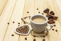 Valentine`s Day concept. Cup of coffee, chocolate, knitted heart, string of pearl beads. Romantic breakfast and gift on wooden