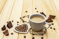 Valentine`s Day concept. Cup of coffee, chocolate, knitted heart, string of pearl beads. Romantic breakfast and gift on wooden