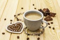 Valentine`s Day concept. Cup of coffee, chocolate, knitted heart, string of pearl beads. Romantic breakfast and gift on wooden