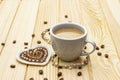 Valentine`s Day concept. Cup of coffee, knitted heart, string of pearl beads. Romantic breakfast and gift on wooden boards