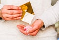 Female hands holding golden paper envelope with hearts. opening gold origami envelope
