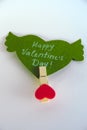 Valentine`s day concept. Green paper heart with wings and congratulation fixed on a clothespin on white background. Royalty Free Stock Photo