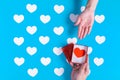 a hand is holding on an opened red gift box with a red heart inside sending to the someone hand Royalty Free Stock Photo