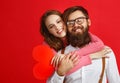 Valentine`s day concept. happy young couple with heart, flowers, gift on red Royalty Free Stock Photo