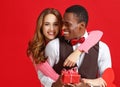 Valentine`s day concept. happy young couple with heart, flowers, gift on red Royalty Free Stock Photo