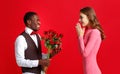 Valentine`s day concept. happy young couple with heart, flowers, gift on red Royalty Free Stock Photo