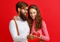 Valentine`s day concept. happy young couple with heart, flowers, gift on red Royalty Free Stock Photo