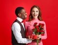 Valentine`s day concept. happy young couple with heart, flowers, gift on red Royalty Free Stock Photo