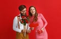 Valentine`s day concept. happy young couple with heart, flowers, gift on red Royalty Free Stock Photo