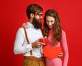 Valentine`s day concept. happy young couple with heart, flowers, gift on red Royalty Free Stock Photo