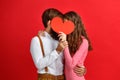 Valentine`s day concept. happy young couple with heart on red