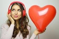 Valentine`s day concept. Lovely girl with red headphones listening to the voice of his heart. Cute young woman listening her red b Royalty Free Stock Photo