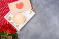 Valentine`s Day concept. Morning coffee, envelope with red heart, roses on grey desk. Free space. Space for text. Royalty Free Stock Photo