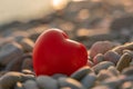 Valentine's Day concept. Red heart romantic love symbol on pebble beach at sunset with copy space. Template for Royalty Free Stock Photo