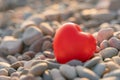 Valentine's Day concept. Red heart romantic love symbol on pebble beach at sunset with copy space. Template for Royalty Free Stock Photo