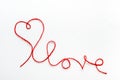 Valentine\'s day concept. Red heart and word love made from woolen rope on white background with copy space