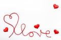 Valentine\'s day concept. Red heart and word love made from woolen rope on white background with copy space