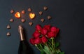 Valentine`s day concept. Red roses, bottle of champagne, burning candles and chocolate candies Royalty Free Stock Photo