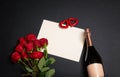 Valentine`s day concept. Red roses, empty card for your text, two red hearts and bottle of champagne