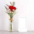 ValentineÃ¢â¬â¢s day concept, Red roses flower bouquet in glass vase and blank grey vintage wooden frame on table background with Royalty Free Stock Photo