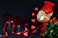 Valentine`s day concept. Teddy bear in heart shaped gift box with candle and red wineglass on black background. Royalty Free Stock Photo