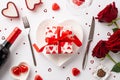 Valentine`s Day concept. Top view photo of heart shaped dish with present box cutlery chocolate candies wine bottle wineglass Royalty Free Stock Photo