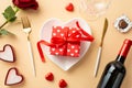 Valentine`s Day concept. Top view photo of heart shaped plate with giftbox knife fork wine bottle candles glass chocolate candies Royalty Free Stock Photo