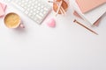 Top view photo of workstation keyboard stack of notebooks pencils holder pen heart shaped candle and cup of frothy coffee Royalty Free Stock Photo