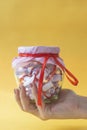 Valentine`s day concept. Woman holding glass jar filled with rolled papers desires, wishes or dreams