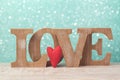 Valentine`s day concept with wooden letters love and heart shape over mint background Royalty Free Stock Photo