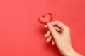 Valentine`s day concept. A young girl holds a heart in her hand on a red background. Copy space Royalty Free Stock Photo